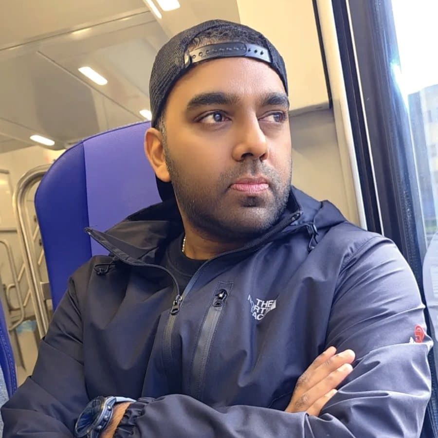 Ash on a train, arms folded, looking out of the window
